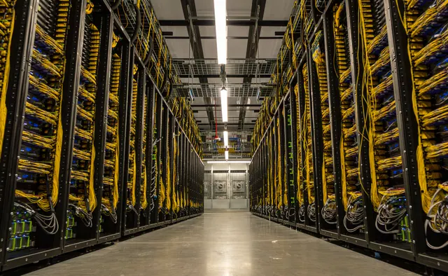 Rows of server racks and yellow network cabling in Meta’s Prometheus announcement photograph.