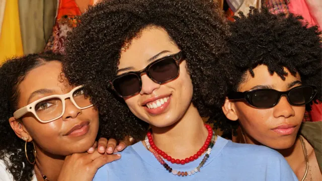 Three people wearing Meta AI glasses in an official product photograph.